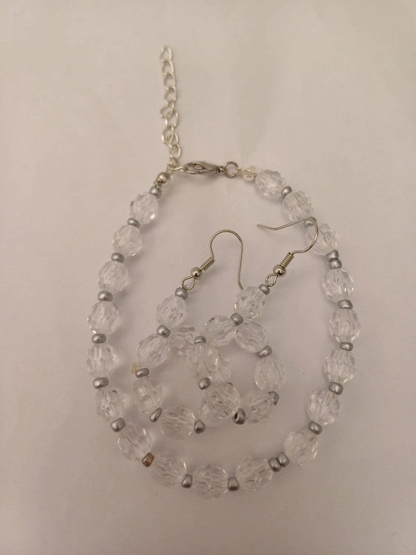 Clear beaded necklace and earrings set with silver accents, displayed on a white background. The necklace features a chain clasp.