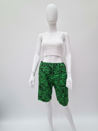 Mannequin wearing a white ribbed crop top and green zebra-striped shorts, set against a plain white background.