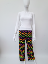A mannequin wearing a white tank top and colorful zigzag-patterned pants in purple, orange, yellow, and green.