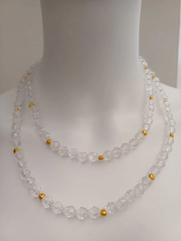 A mannequin displays a double-strand necklace made of clear, faceted beads with gold spacers. The necklace drapes elegantly across the neck and chest.