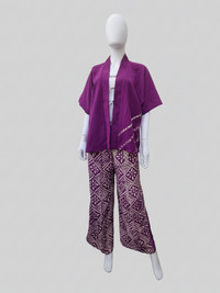 Mannequin wearing a purple kimono-style top and patterned wide-leg pants with a geometric design on a neutral background.