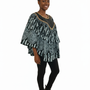 A smiling woman stands against a white background, wearing the Black & Mint Green Ankara Batik Poncho Top with black leggings and boots. Her hair is styled in a high puff.