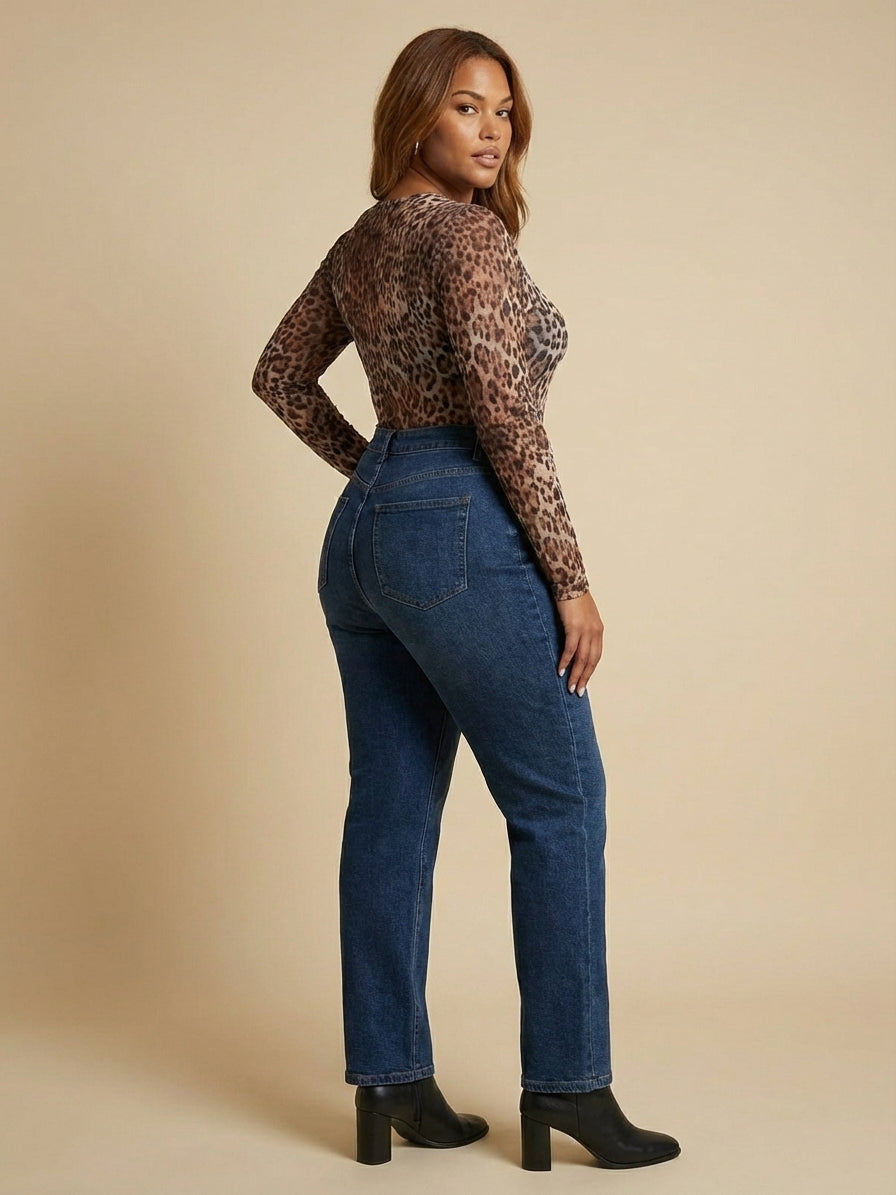 A person wearing a leopard print long-sleeve top and blue jeans stands in profile against a beige background. They are wearing black heeled boots.